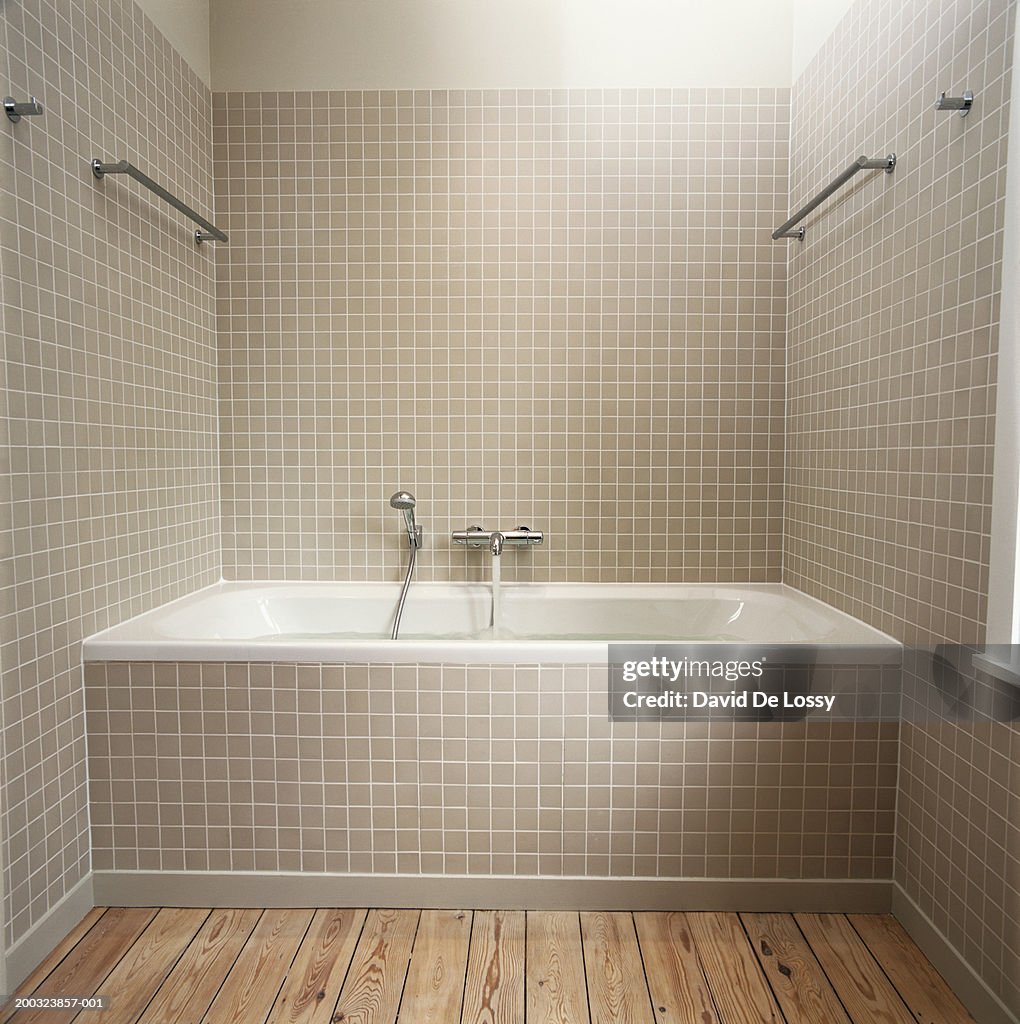 Running water flowing from faucet into bathtub