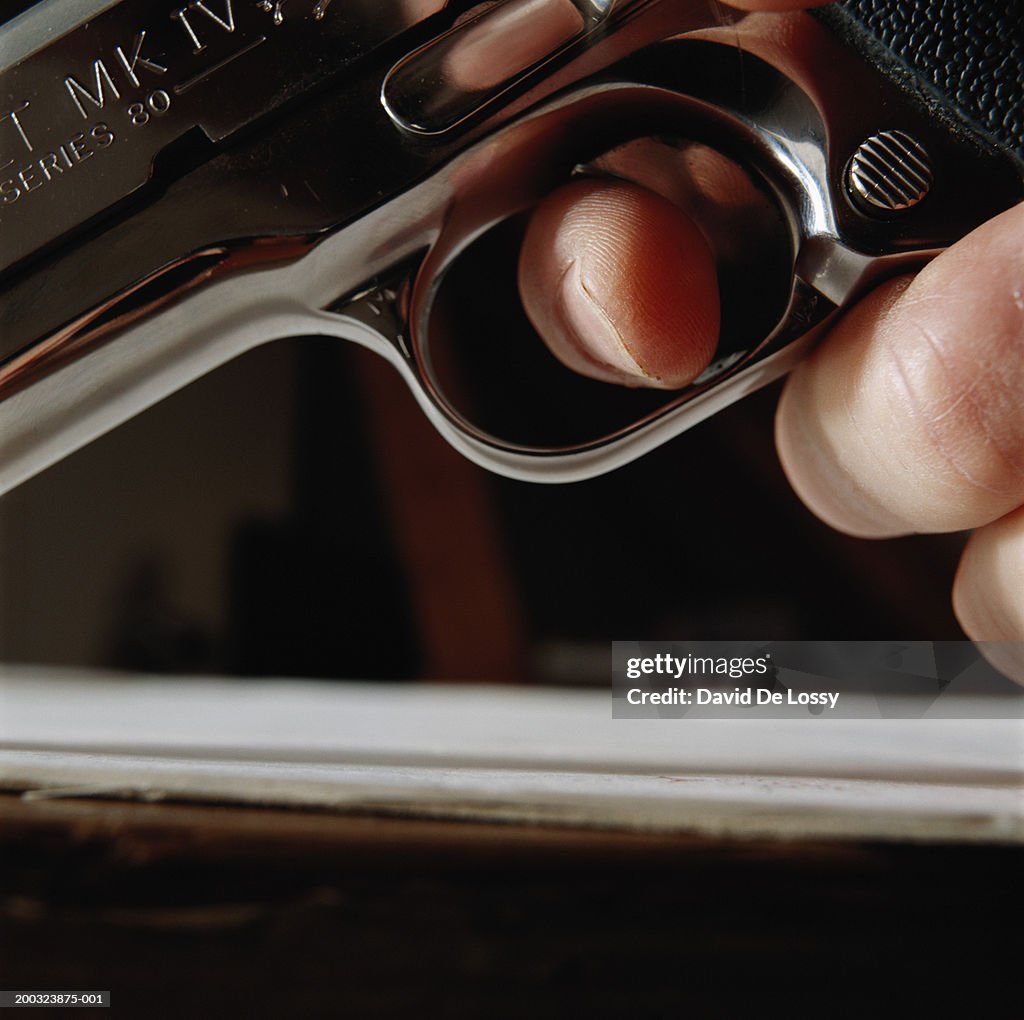 Hand holding gun, close-up, low angle view