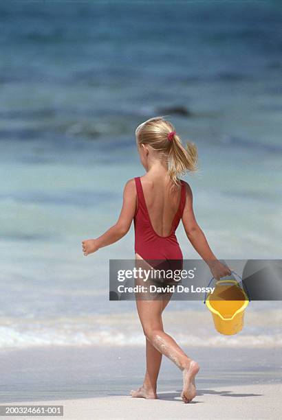 Girl Holding Bucket Walking Towards Sea Rear View High-Res Stock