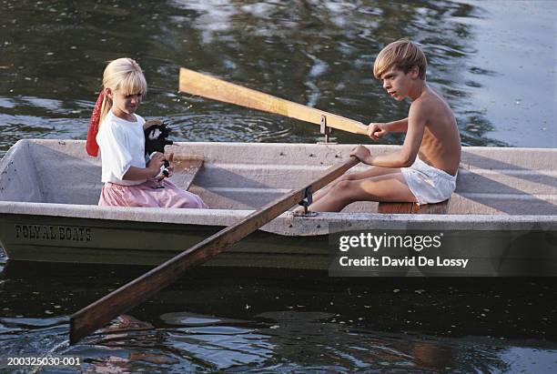 girl (4-5) and boy (8-11) in boat, boy rowing, elevated view - 6 loch stock pictures, royalty-free photos & images