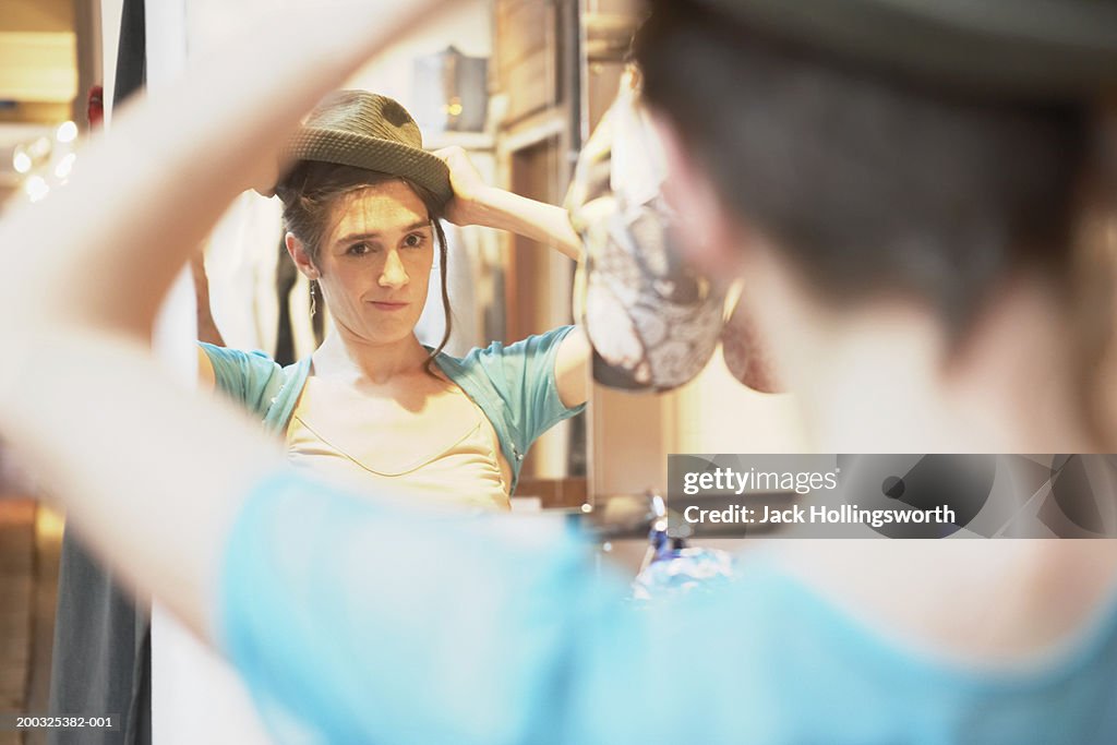 Reflection of a young woman in the mirror wearing a hat