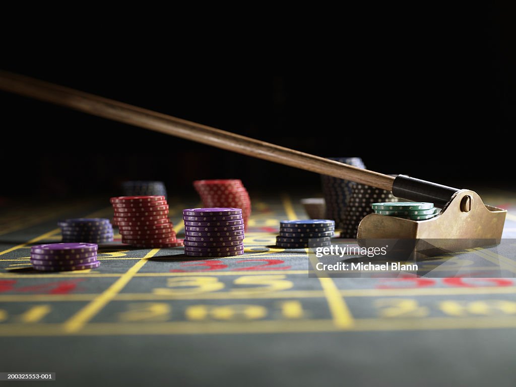 Roulette rake gathering gambling chips on gaming table