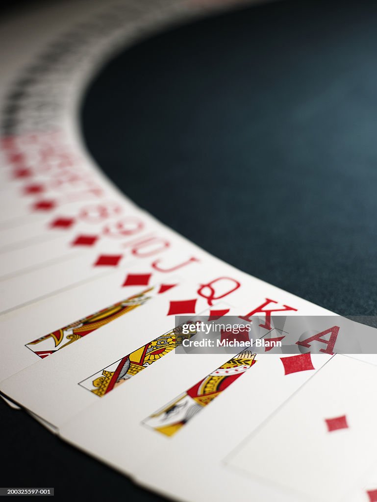 Playing cards spread out in arc, suit of diamonds in foreground