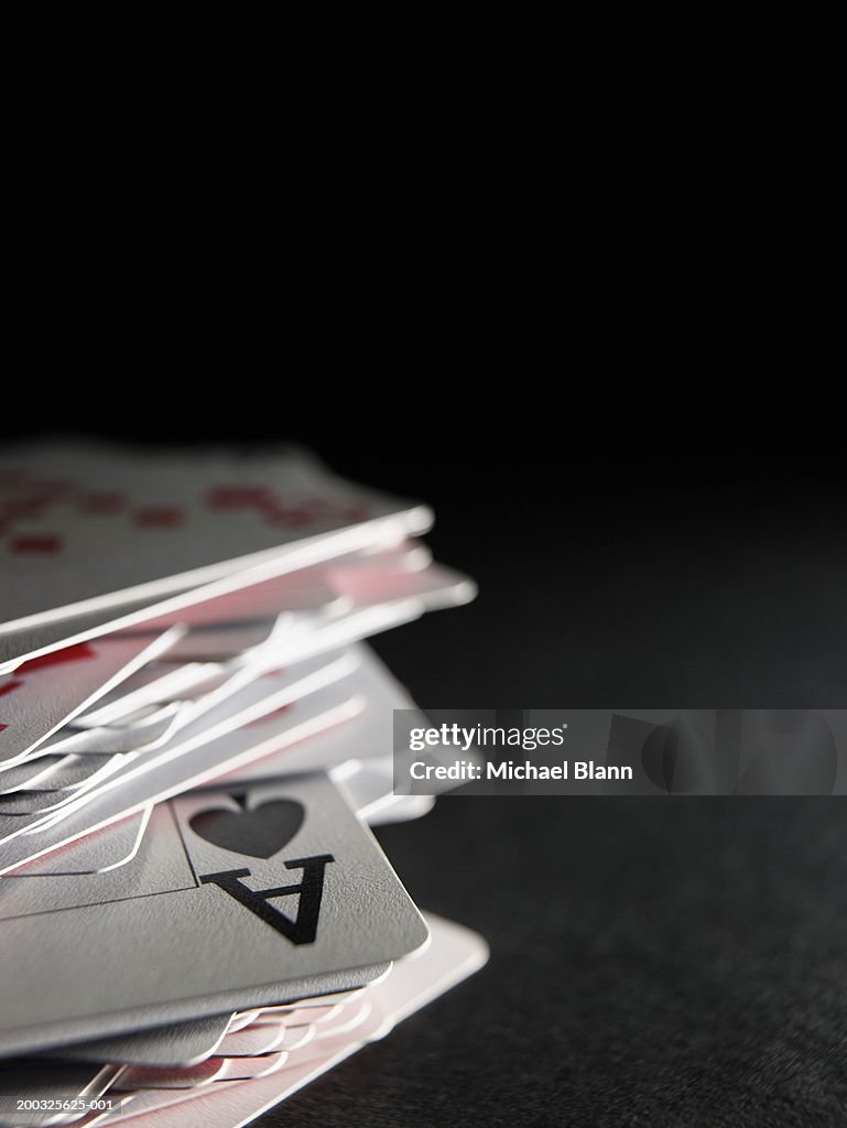 Ace of spades in stack of playing cards, close-up