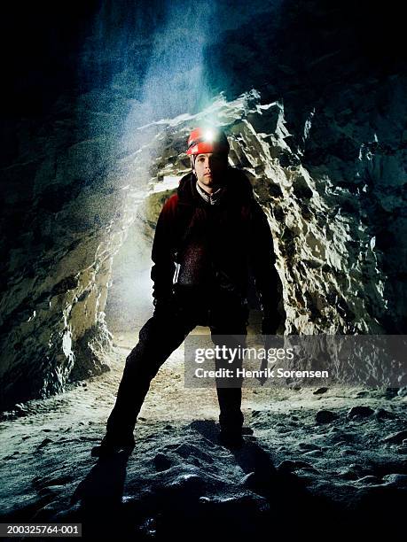 young male mountain climber standing in cave - caving stock pictures, royalty-free photos & images