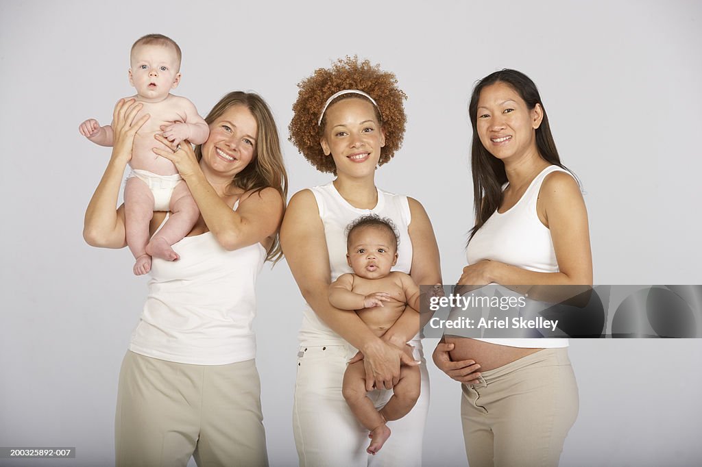Two mothers and baby boys (3-5) months with expectant mother, portrait