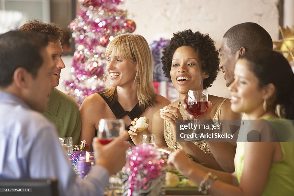 Friends at table having christmas dinner, smiling