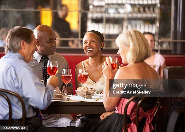 mature couples having drinks in restaurant, smiling - black couple dining stockfoto's en -beelden