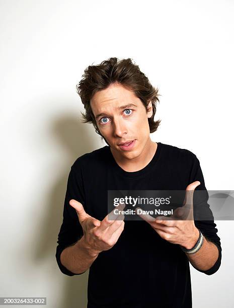 young man shrugging shoulders, portrait, close-up - young man blue eyes stock pictures, royalty-free photos & images