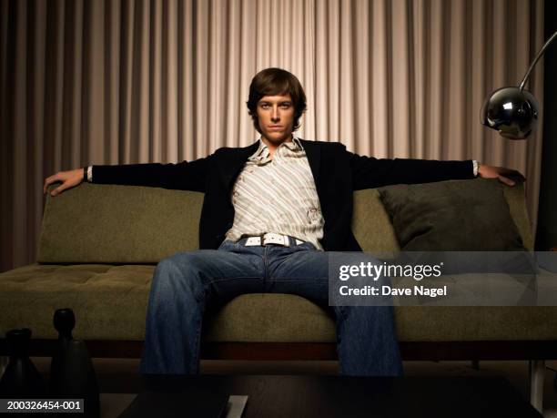 young man sitting on couch, portrait - sitting on couch imagens e fotografias de stock