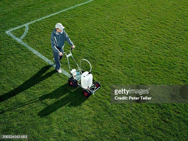 young man using field line marker, elevated view - yard line stock pictures, royalty-free photos & images