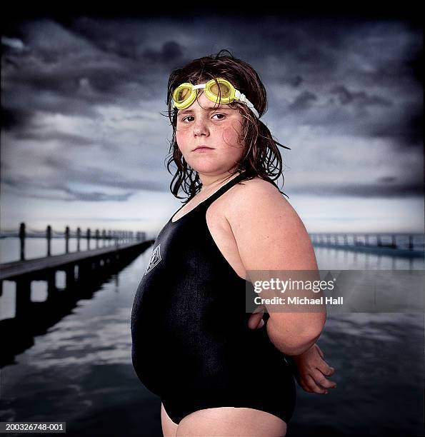 girl (7-9) wearing swimming costume by outdoor swimming pool, portrait - chubby girls photos fotografías e imágenes de stock