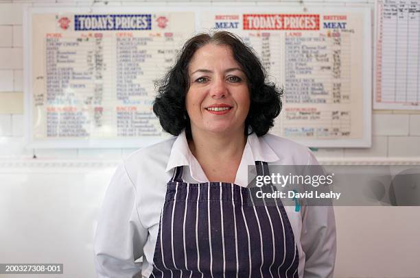 female butcher wearing apron, smiling, portrait, close-up - butcher portrait stock pictures, royalty-free photos & images