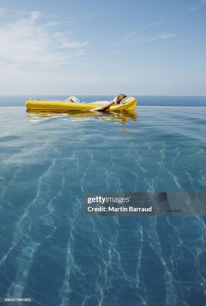 Infinity Pool Raft Boy Relaxing On Inflatable Raft In Infinity Pool High-Res Stock Photo ...