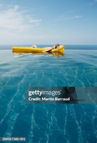Boy Inflatable Raft Boy Relaxing On Inflatable Raft In Infinity Pool High-Res Stock Photo ...