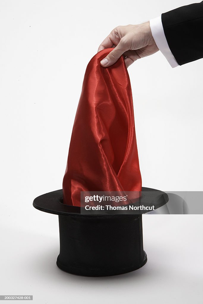 Man pulling scarf out of top hat, close-up of hand