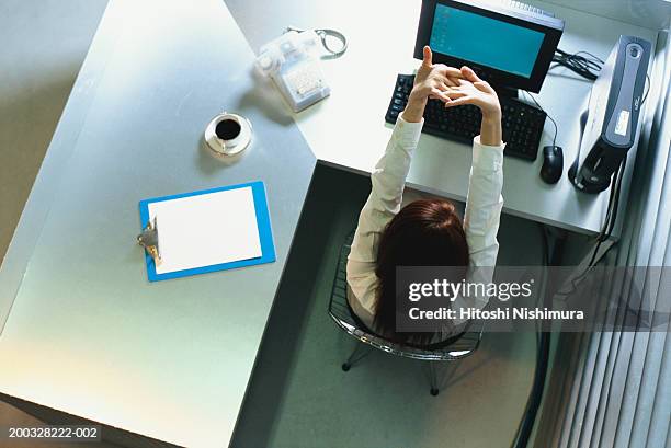 woman stretching hands at office desk, elevated view - office stretches stock pictures, royalty-free photos & images