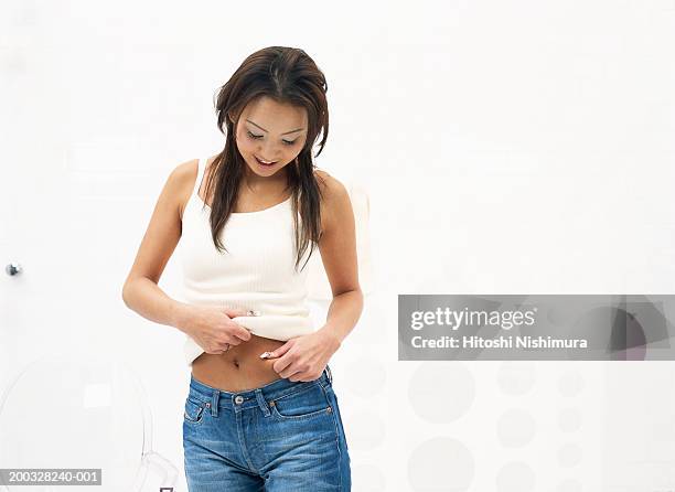 young woman pinching stomach - female navel ストックフォトと画像