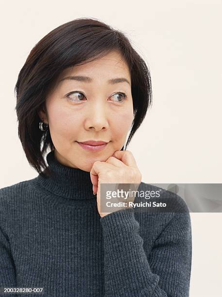 woman with hand on chin looking to side, close-up - neckline stock pictures, royalty-free photos & images