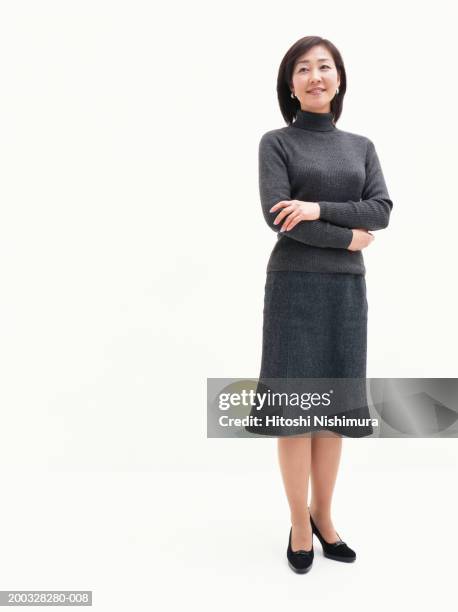 young woman with arms crossed, looking away, low angle view - front on portrait older full body foto e immagini stock