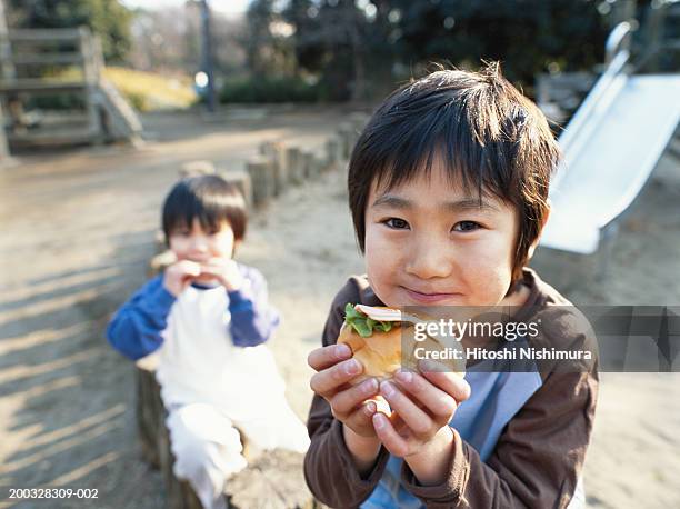 boys (4-6) eating hamburger outdoors, portrait - kid eating burger bildbanksfoton och bilder