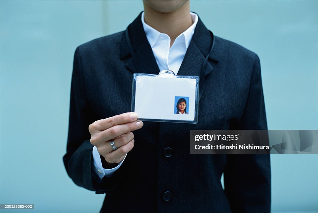 Woman showing identity card, mid section