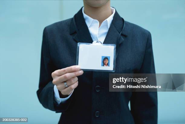 woman showing identity card, mid section - carta didentità foto e immagini stock