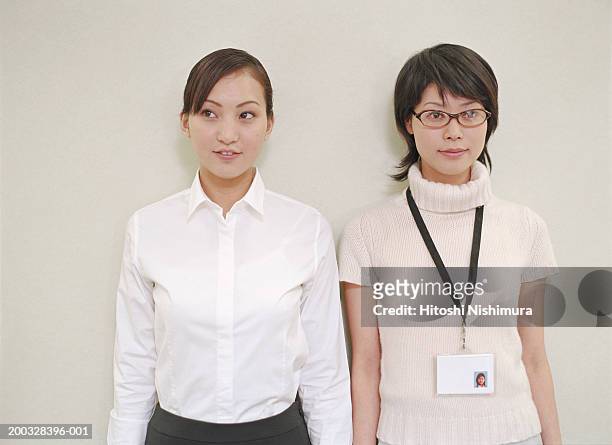 two young women leaning against wall - security pass stock pictures, royalty-free photos & images