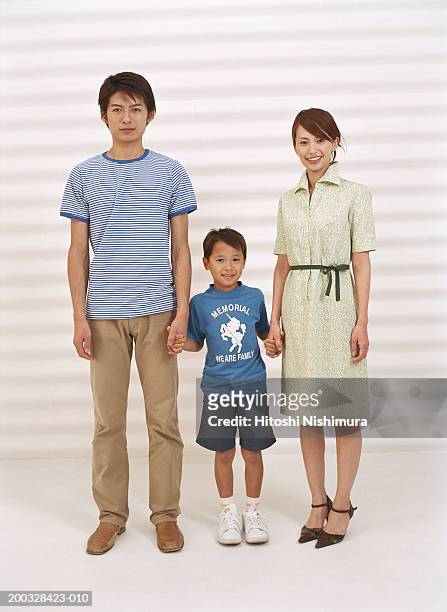 parents with son (4-7) standing, holding hands, portrait - short sleeved 個照片及圖片檔