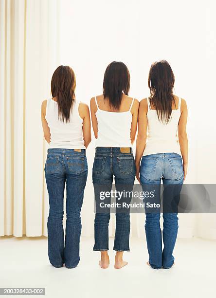 three women standing in row, rear view - architectonisch element stockfoto's en -beelden