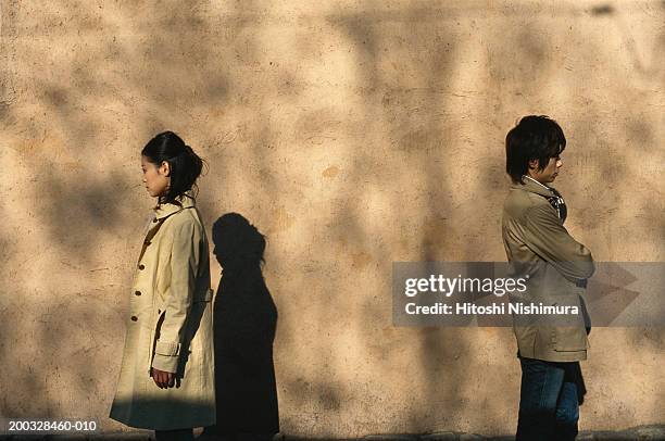 young couple standing away outdoors, back to back - asian couple arguing stockfoto's en -beelden