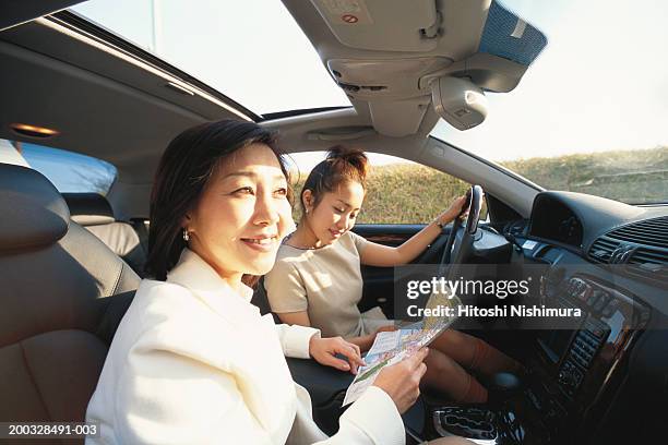 two women sitting in car, looking at map, elevated view, close up - daughter driving stock pictures, royalty-free photos & images