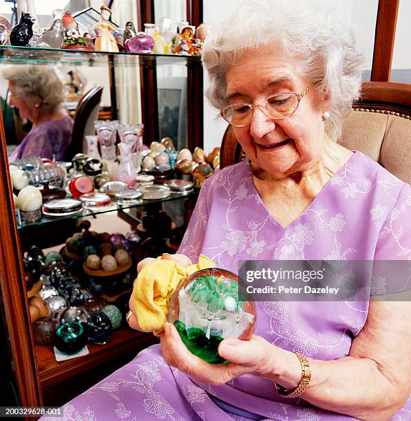 senior woman sitting polishing paperweight, close up - collect stock pictures, royalty-free photos & images