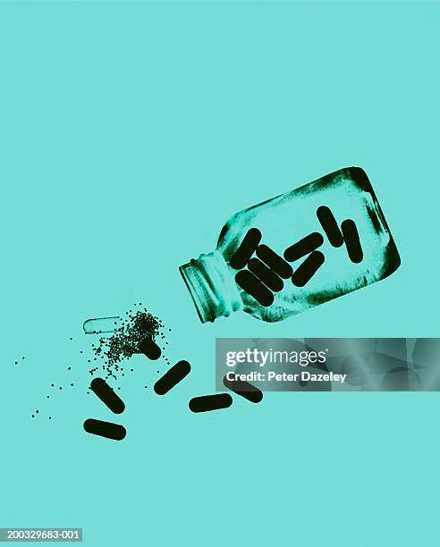 capsules and pills spilling from bottle, close up (paper negative) - vício fotografías e imágenes de stock