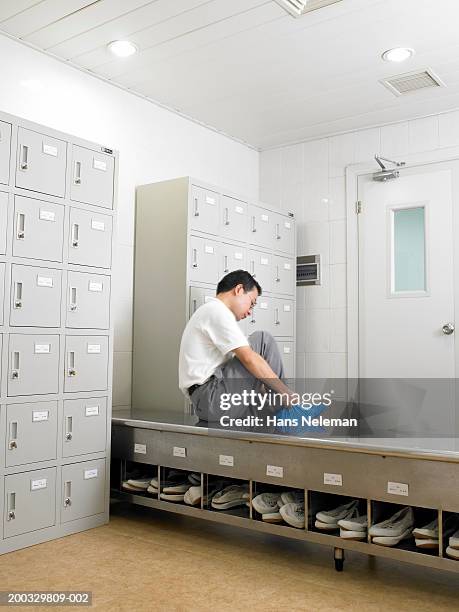 workers putting on protective foot coverings in locker room - protective footwear stock pictures, royalty-free photos & images