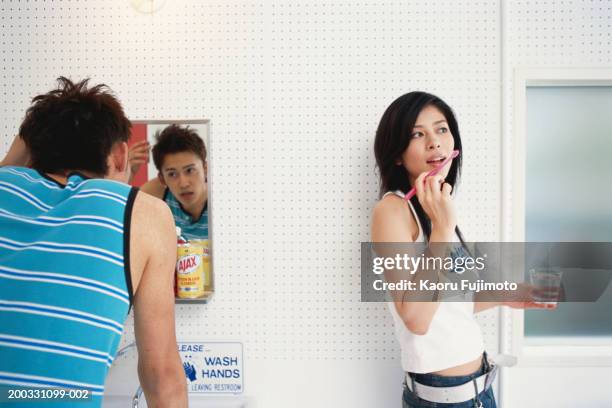 man looking in mirror, woman holding glass and toothbrush - asian man long hair stock pictures, royalty-free photos & images