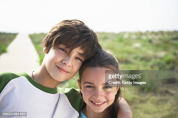 boy and girl (8-10) on beach boardwalk, close-up, portrait - sibling stock pictures, royalty-free photos & images