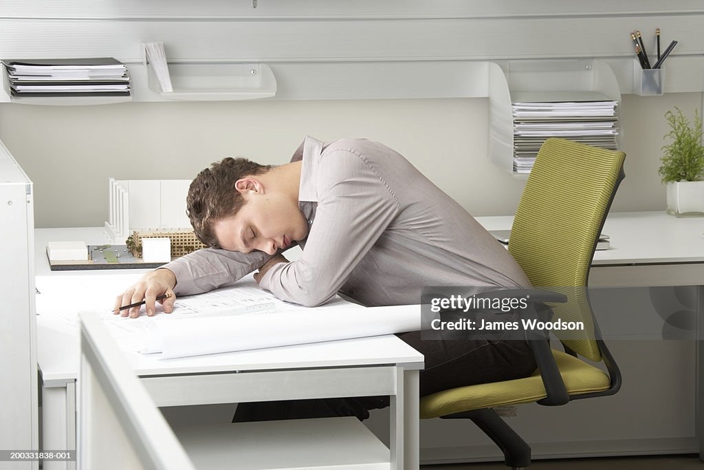 Young businessman asleep on desk