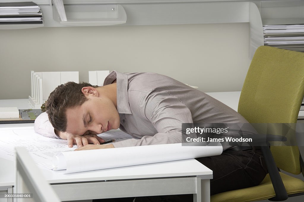 Young businessman asleep on desk