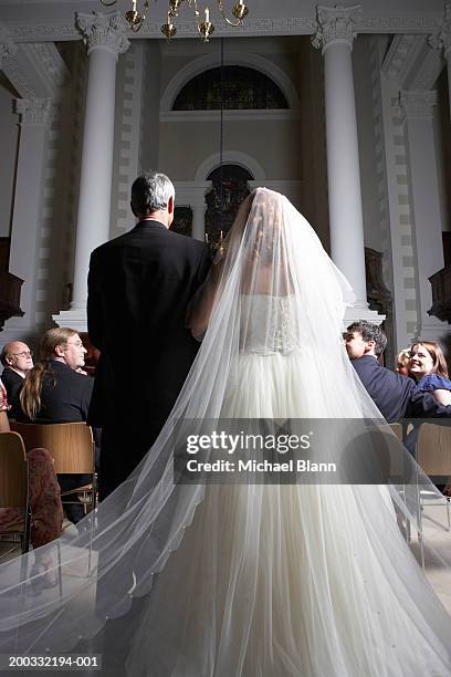 father walking bride down church aisle, rear view - père de la mariée photos et images de collection