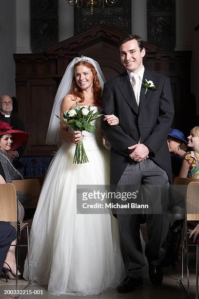 bride and groom walking down aisle, smiling - tail coat stock pictures, royalty-free photos & images