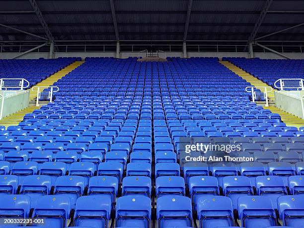 rows of blue seats in stadium - empty seat photos et images de collection