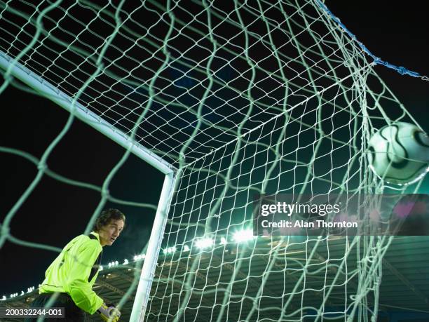 male goalkeeper watching ball bulging in back of net - netting 個照片及圖片檔