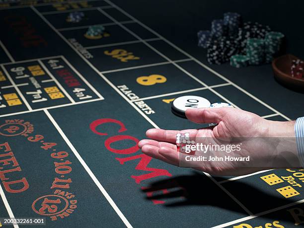 man holding dice at craps table, close-up - クラップス ストックフォトと画像