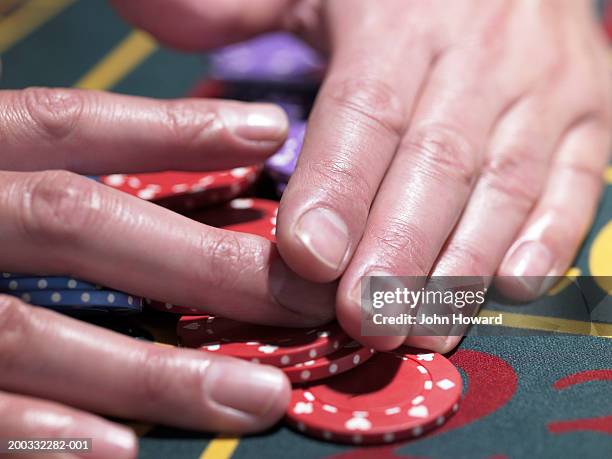 man gathering pile of chips at roulette table, close-up - casino tables hands stock pictures, royalty-free photos & images