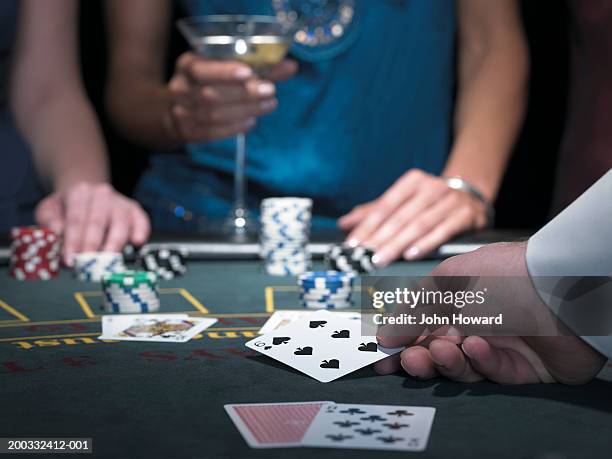 two women playing blackjack, croupier turning over card, close-up - casino dealer stockfoto's en -beelden