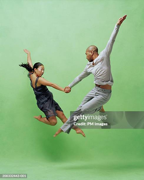 young male and female dancers leaping - asian man barefoot foto e immagini stock