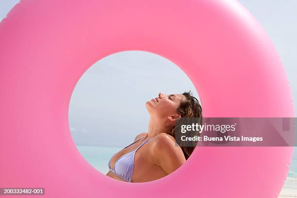 woman at beach, side view - vista posterior stockfoto's en -beelden
