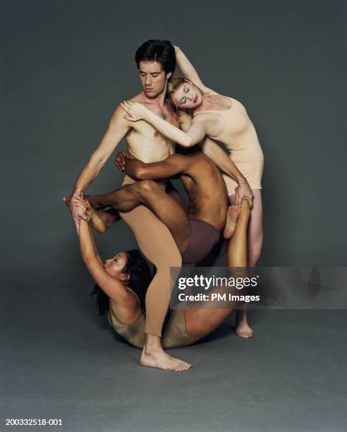four young male and female modern dancers in circular pose - entrelacement photos et images de collection