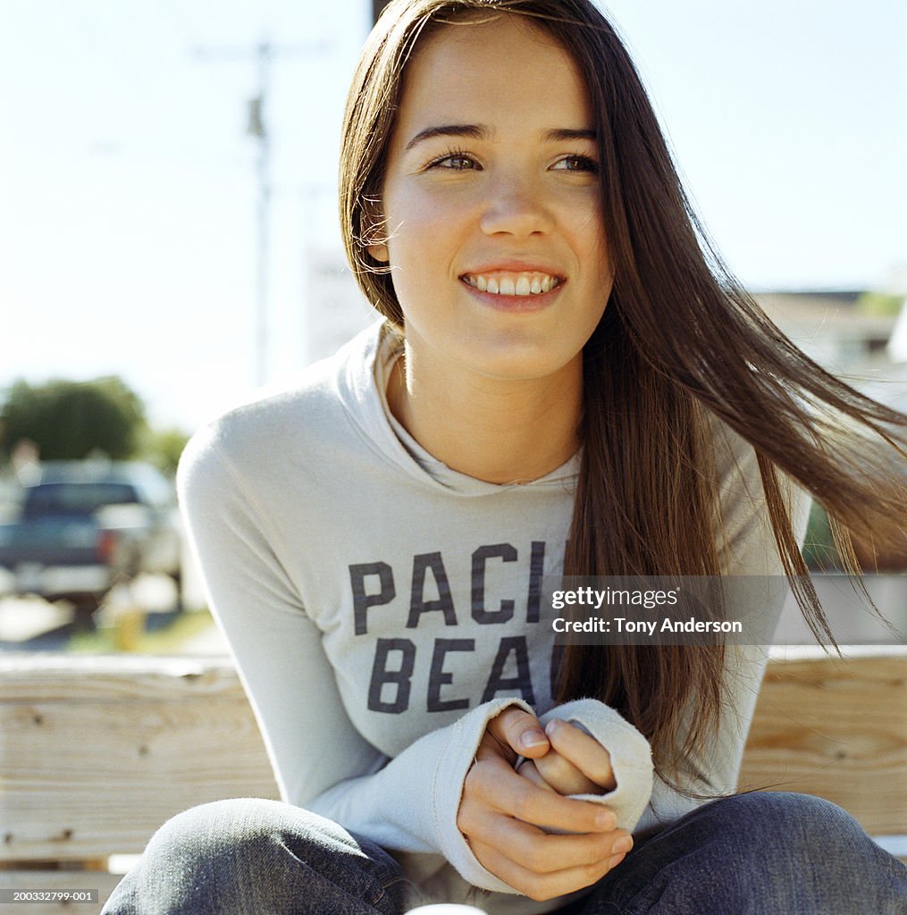 Young woman on bench smiling, close-up